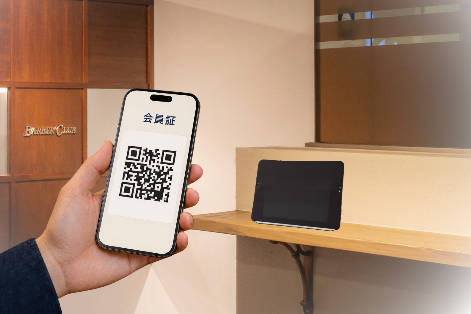 スマートフォンに表示した会員証のQRコードを、店内のリーダーにかざしてチェックインする様子