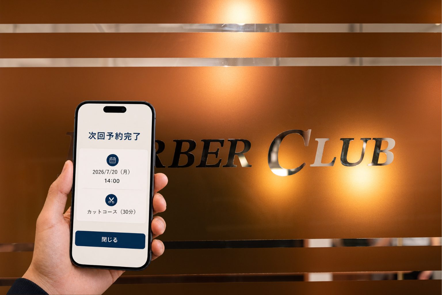店内のBARBER CLUBのサインを背に、スマートフォンで次回予約の完了画面を表示しているところ